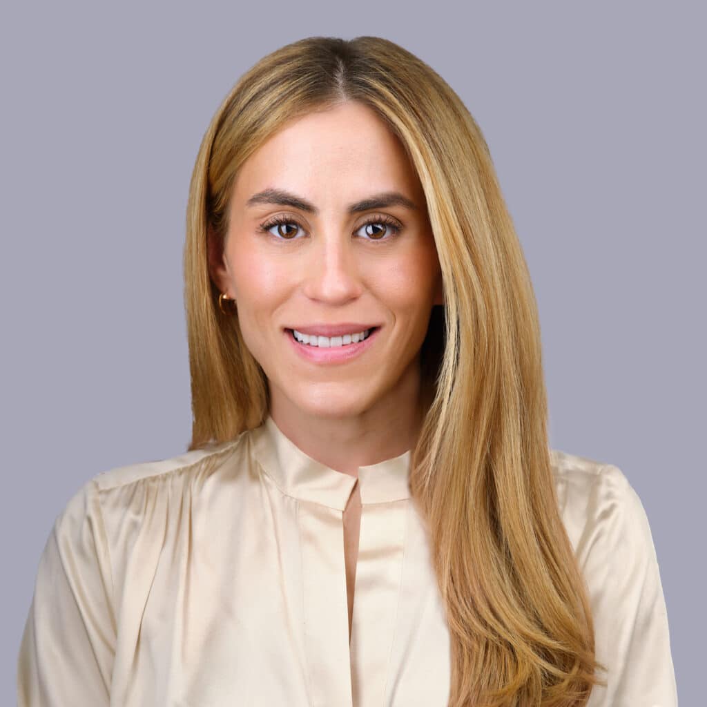 Professional headshot of a smiling woman with long blonde hair